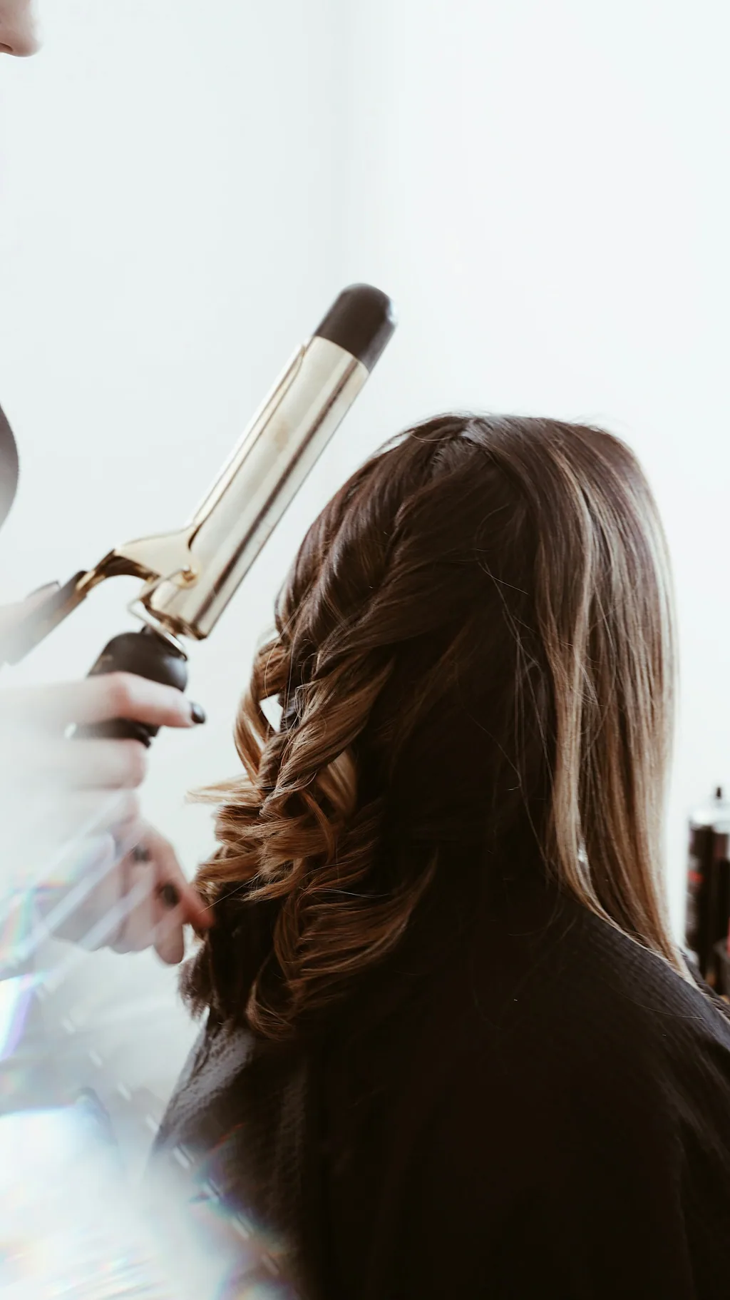 Elegant hair styling preparation in warm, calm light